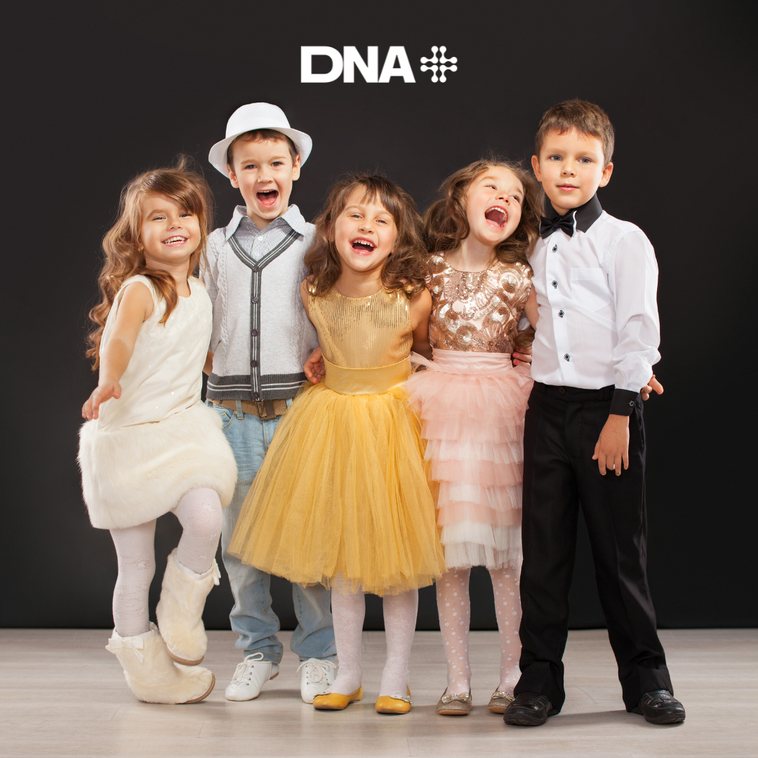 Children in formal attire posing together with a 'DNA' logo above them.